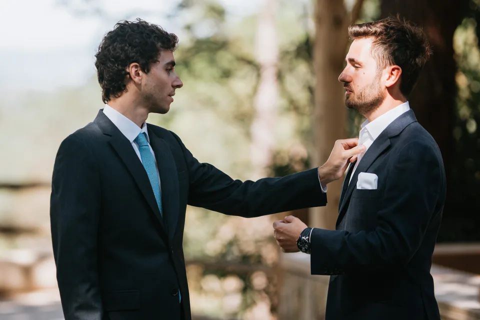 Two men in suits sharing a moment before the ceremony