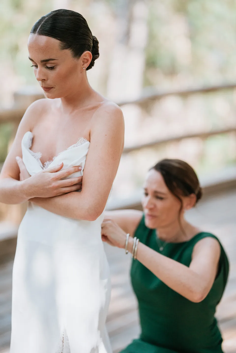 Someone adjusting the bride’s dress before the ceremony