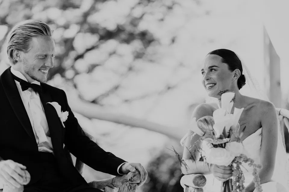 Newlyweds sharing a smile during the ceremony, in black and white