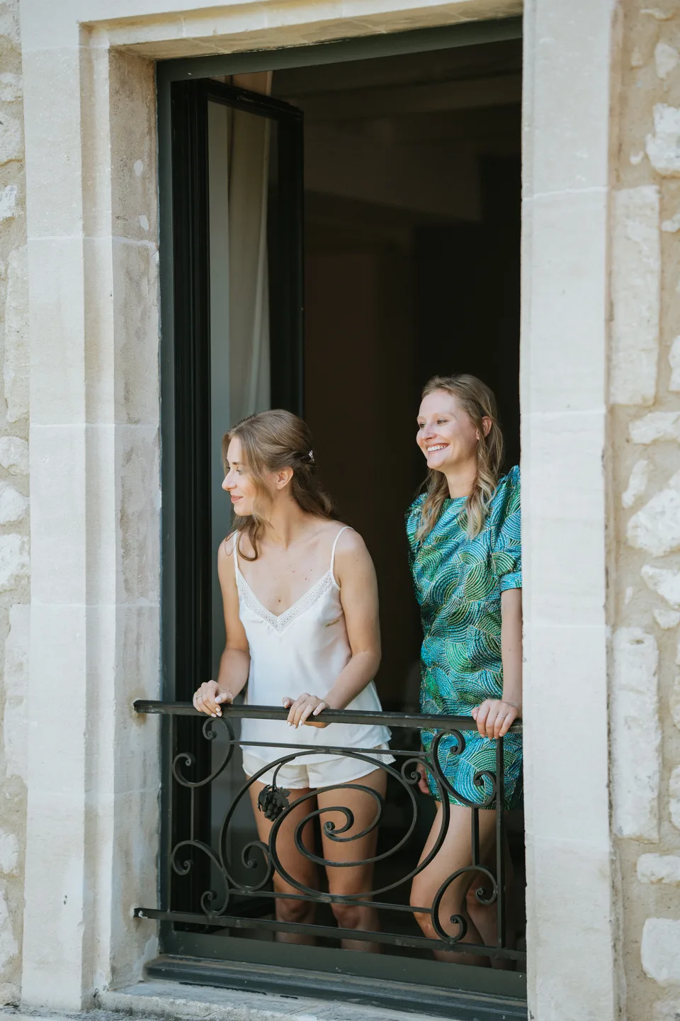 The bride and a loved one at an open window