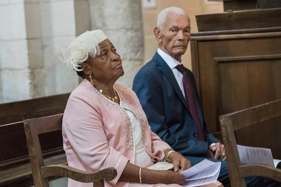 Two guests seated in the church pews