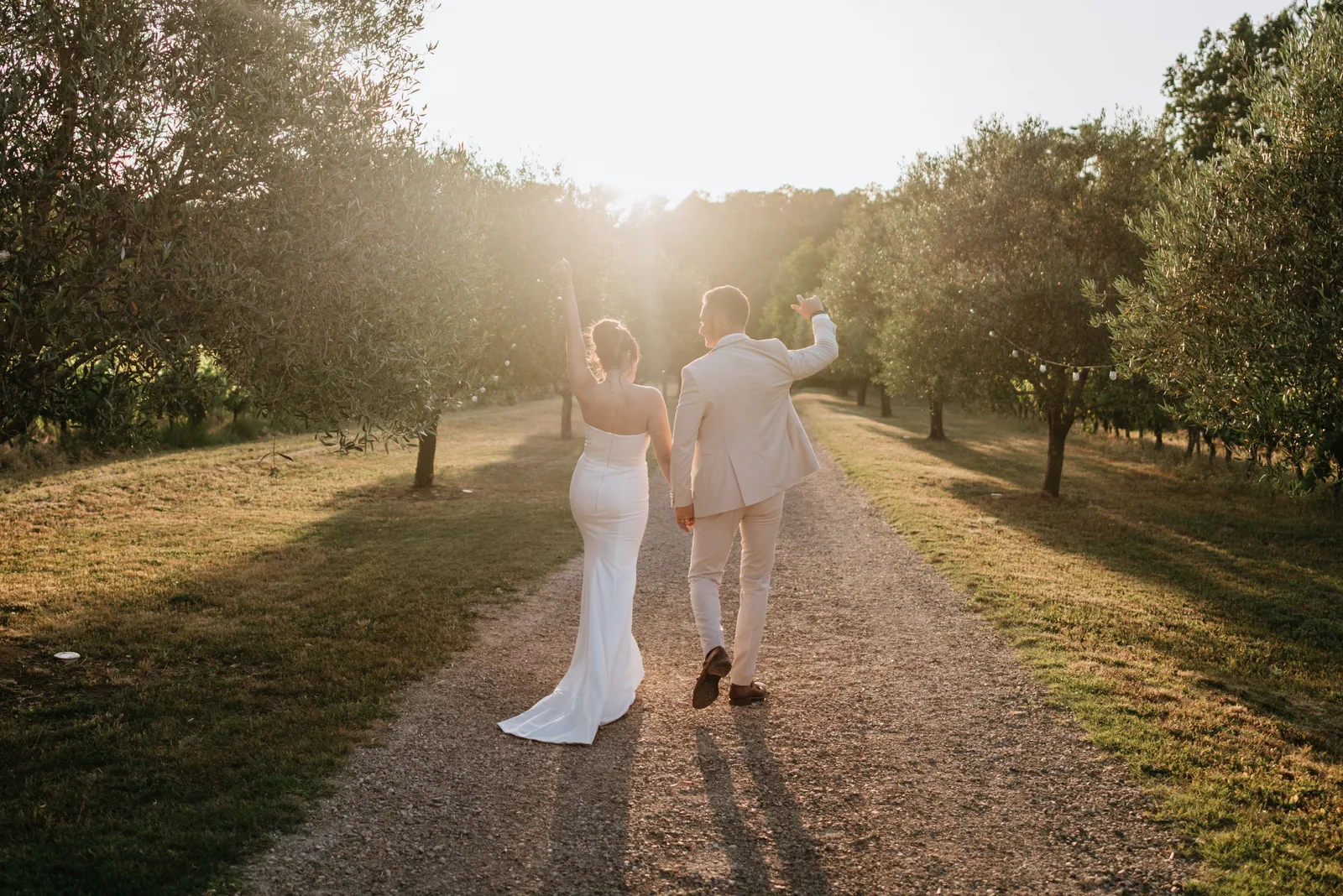 Newlyweds walking along a path at sunset