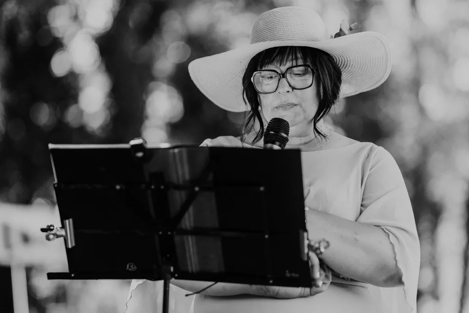 A guest reading into a microphone, in black and white