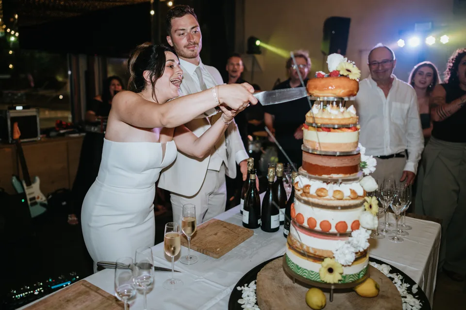 Newlyweds beside their wedding cake