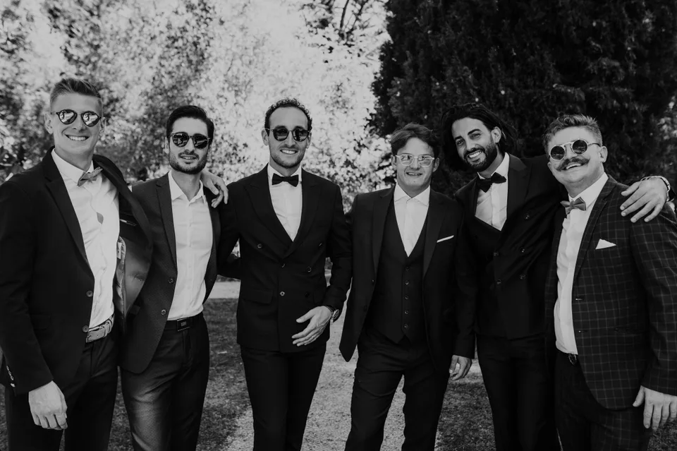A group of guests laughing together in black and white
