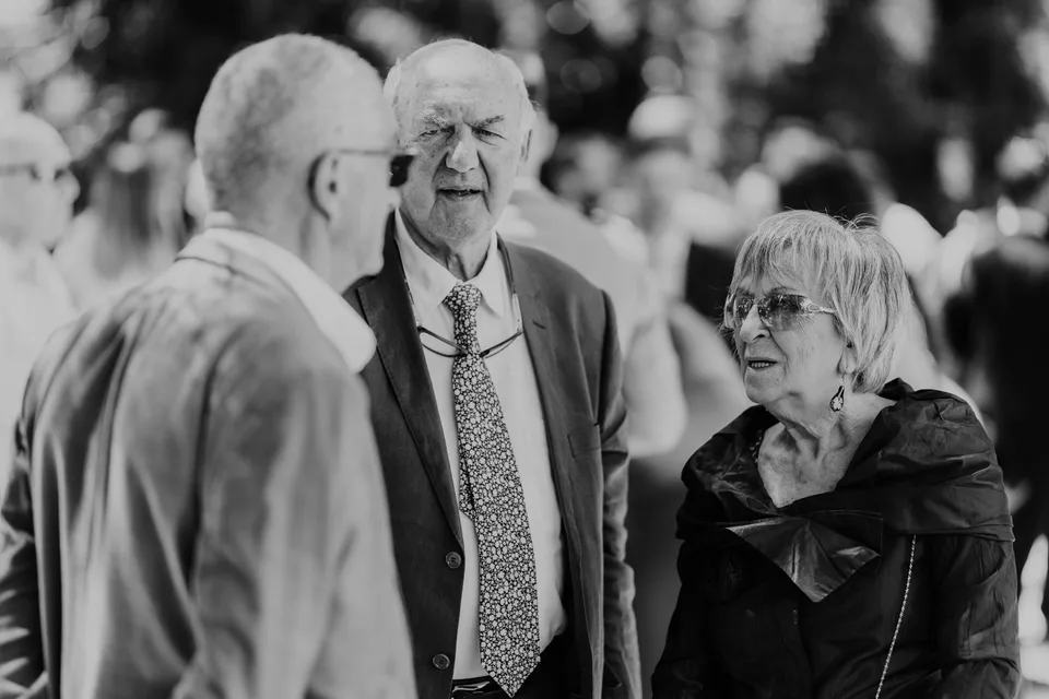 Guests talking outdoors, in black and white