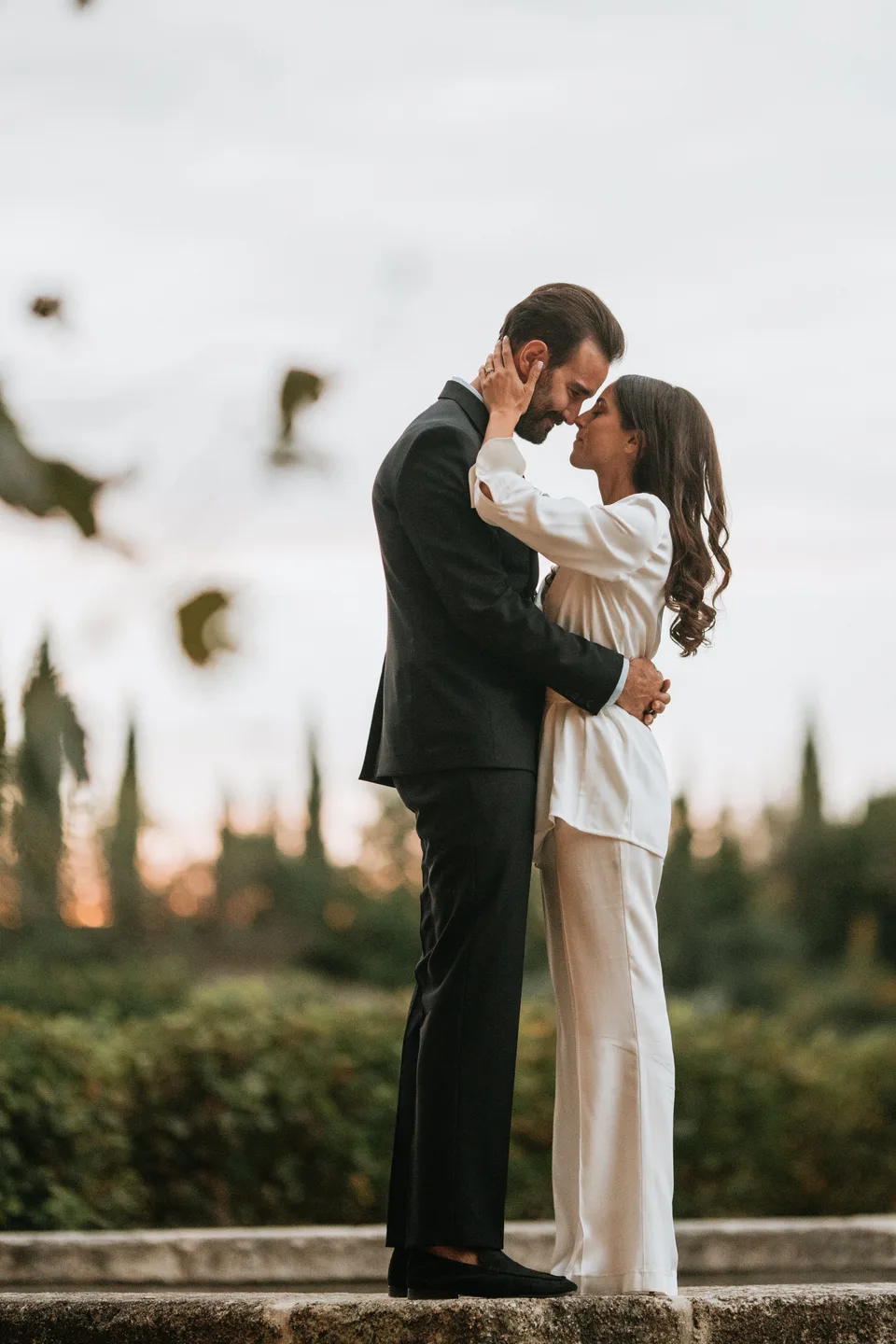 Newlyweds kissing beneath string lights