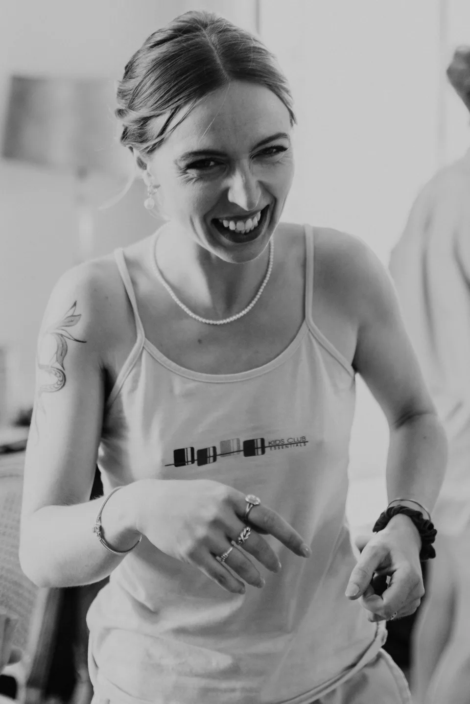 The bride laughing during preparations, in black and white