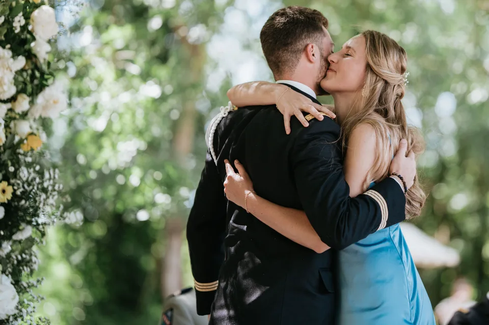 An embrace in front of the floral ceremony setting