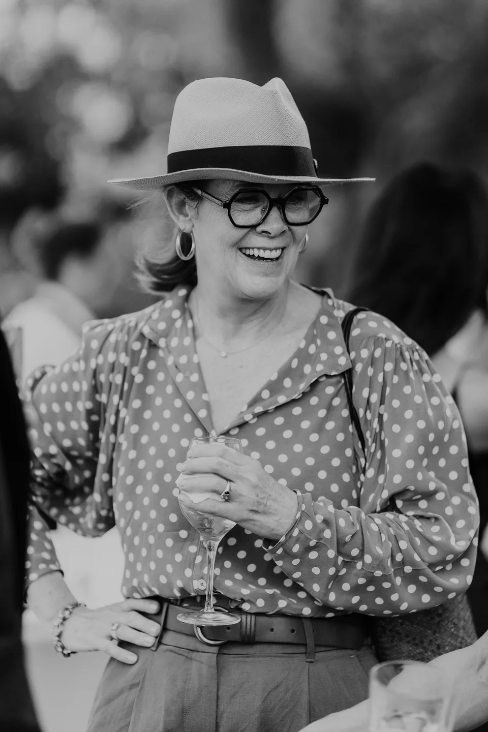 A guest in a hat smiling, in black and white