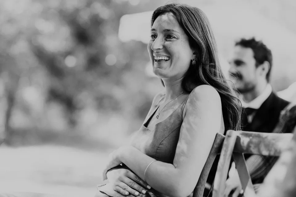 A guest smiling during the ceremony, in black and white
