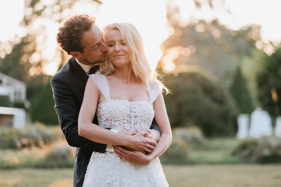 Newlyweds embracing in sunset light