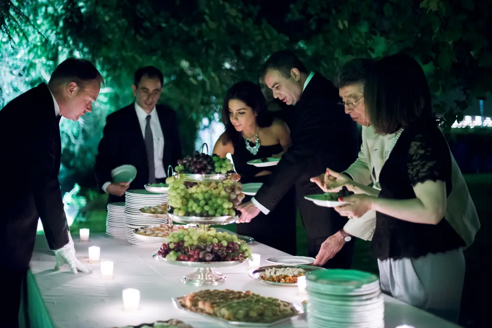Newlyweds and guests gathered around the cake