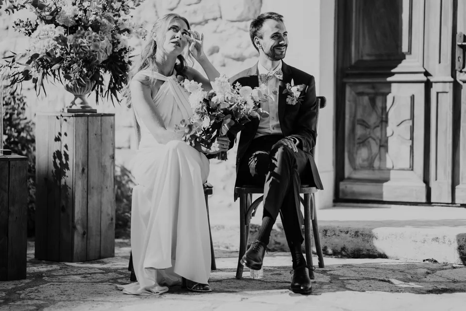 Newlyweds kissing after the ceremony, in black and white