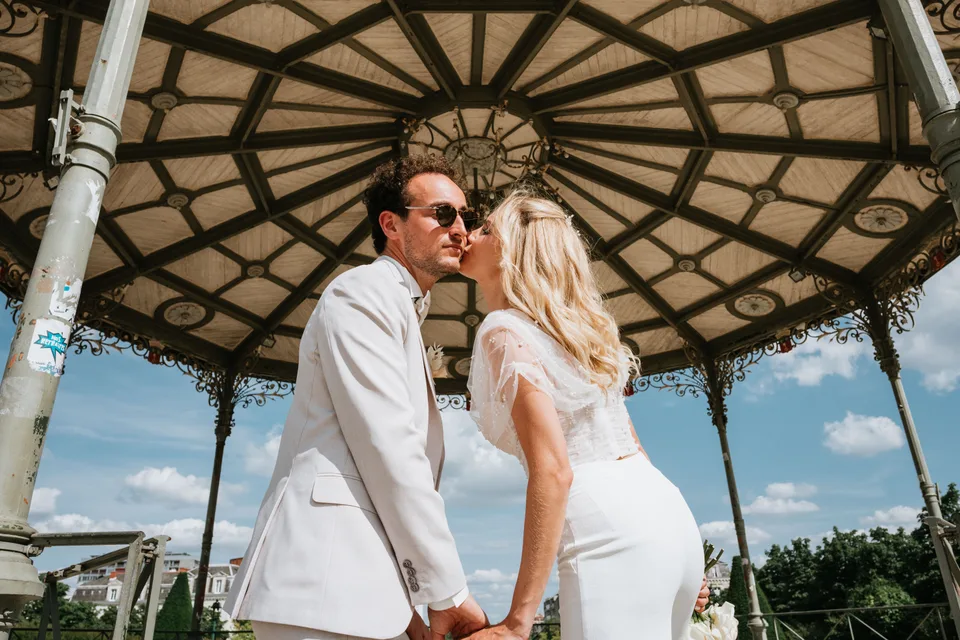 Newlyweds holding hands beneath a pavilion