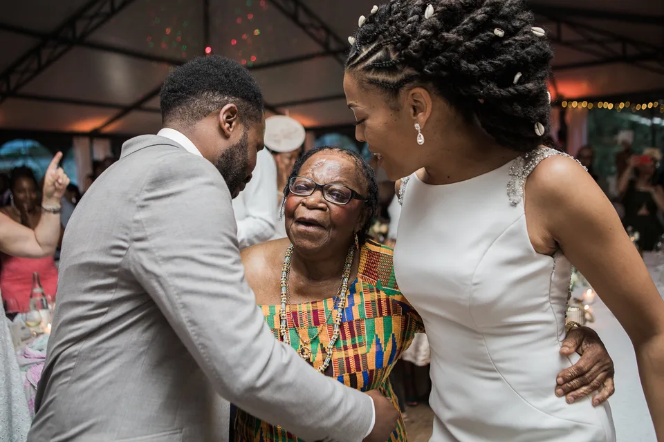 Newlyweds kissing a guest at the reception