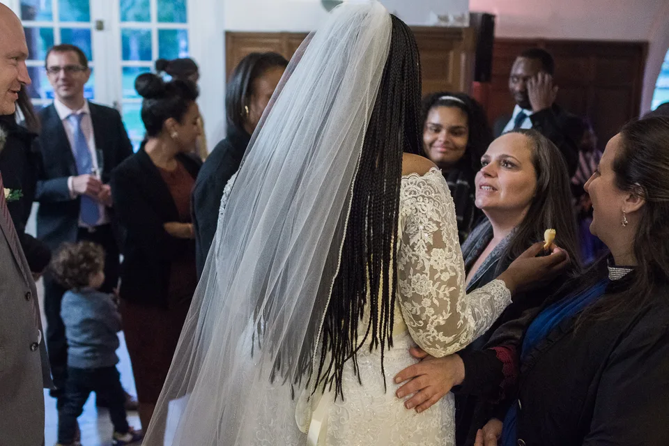 Guests smiling around the bride indoors