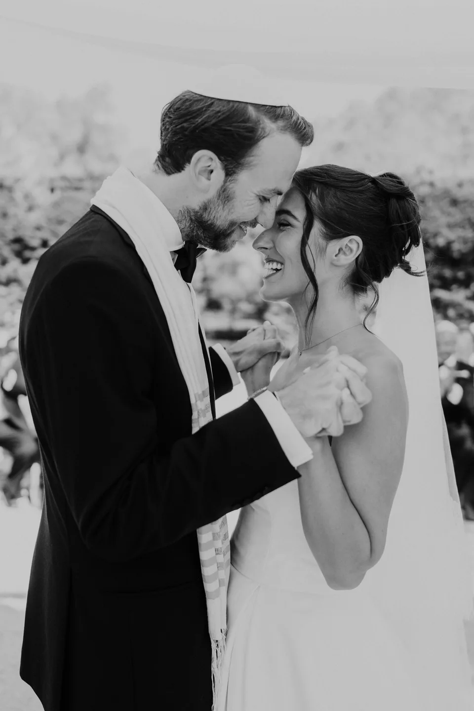 A kiss on the bride’s forehead, in black and white
