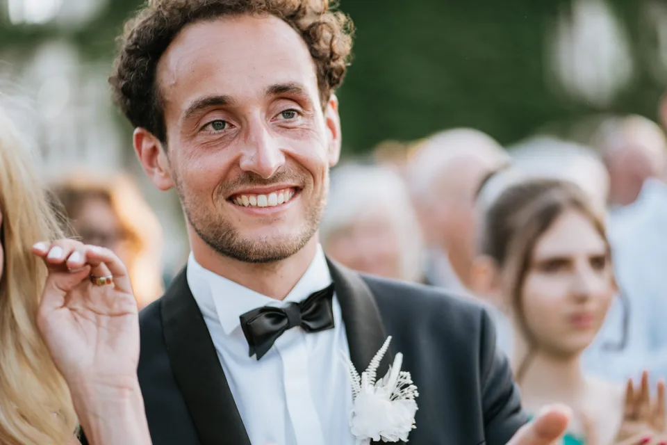 The groom smiling during the outdoor ceremony