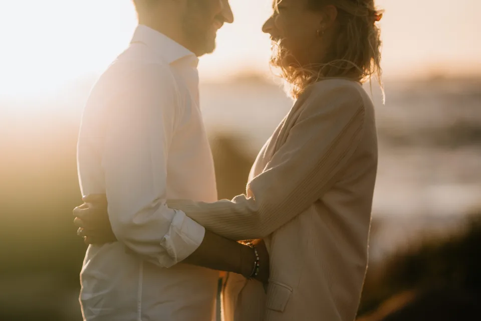 Newlyweds holding each other at sunset