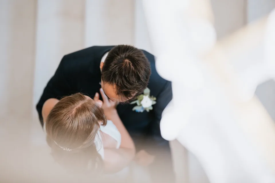 The groom leaning towards a young guest